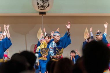 Tokushima Prefecture, Japan - August 14 2024 : Tokushima Awa Odori Festival 2024. Performers are performing Japanese traditional Awa dance on the indoor stage. clipart