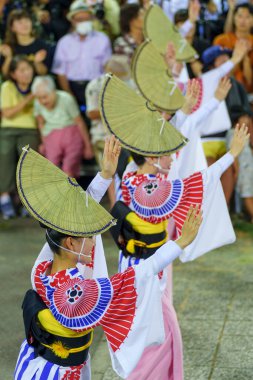 Tokushima Prefecture, Japan - August 14 2024 : Tokushima Awa Odori Festival 2024. Performers wear traditional obon costumes, dance and sing in a formation as they parade through the outdoor stage at night. clipart