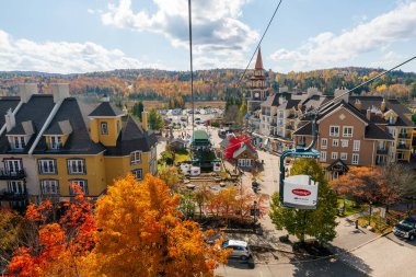 Mont-Tremblant, Quebec, Kanada - 14 Ekim 2022: Mont Tremblant Kayak Tatil Köyü sonbahar akçaağaç manzarası. Güneşli bir günde Cabriolet teleferik gezisi..