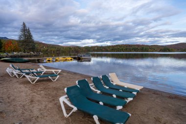 Göl kıyısındaki plaj sandalyeleri. Ouimet Gölü (Lac Ouimet) sonbahar manzarası. Mont-Tremblant, Quebec, Kanada.