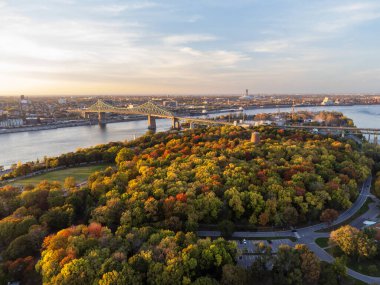 Jean-Drapeau Parkı 'nın sonbahar günbatımında Saint Helen Adası' nın havadan görünüşü. St. Lawrence Nehri, Jacques Cartier Köprüsü arka planda. Montreal, Quebec, Kanada.