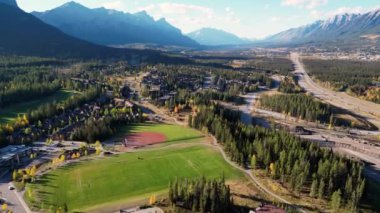 Sonbaharda Canmore Kasabası yerleşim alanı ve Trans-Canada Otoyolu 'nun (1. Arkadaki Kanada Dağları sıradağları. Alberta, Kanada.