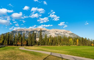 Üç Kız Kardeş Spor Kompleksi Çok Kullanımlı Saha ve Oyun Alanı. Canmore, Alberta, Kanada. Arkadaki mavi gökyüzü üzerindeki Kanada Dağları sıradağları.
