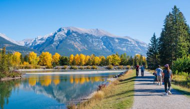 Canmore, Alberta, Kanada - Ekim 12022: İnsanlar sonbaharda Bow Nehri nehir kenarı patikası boyunca yürüyorlar. Plante Yolu Çalıştır.