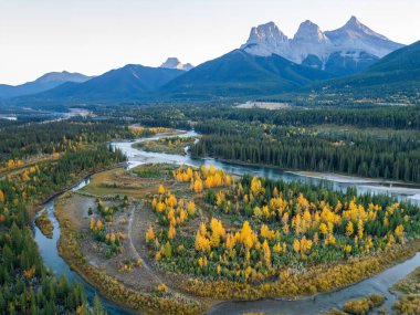 Sonbaharda şafak vakti Kanada Dağları ve Bow Nehri ormanlarının hava manzarası. Canmore, Alberta, Kanada. Üç Kız Kardeş Tepeler Üçlüsü.