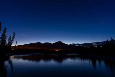 Piramit Dağı silüeti alacakaranlık vakti Athabasca Nehri 'ne yansıdı. Geceleri Jasper kasabası. Alberta, Kanada.