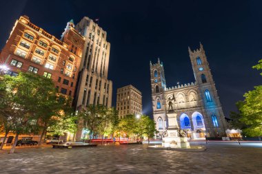 Montreal, Quebec, Kanada - 18 Ağustos 2021: Place d 'Armes in Old Montreal gece manzarası. Notre-Dame Bazilikası. Maisonneuve Anıtı.