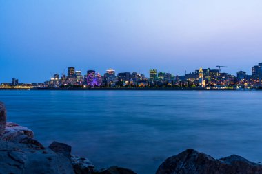 Montreal şehir merkezinin ufuk çizgisi ve Saint Lawrence Nehri alacakaranlıkta, Quebec, Kanada.