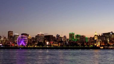 Montreal 'in eski limanı ve geceleri gökyüzü. Renkli binaların ışıkları suya yansıyor. Montreal şehri, Quebec, Kanada.