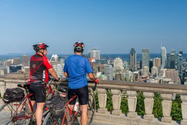 Montreal, Quebec, Kanada - 10 Ağustos 2021: İnsanlar Montreal şehir merkezindeki Mount Royal Park 'taki Kondiaronk Belvedere gözcülüğünden nefes kesici panoramik manzaranın keyfini çıkarıyorlar.