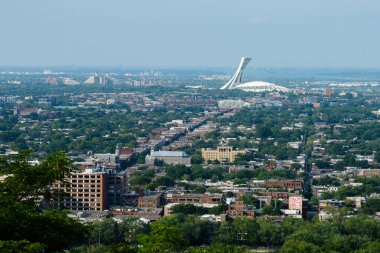 Montreal 'in doğu yakasının panoramik manzarası ve Mount Royal Park' taki Camillien-Houde Gözcüsü 'nden ikonik Olimpiyat Stadyumu. Montreal, Quebec, Kanada.