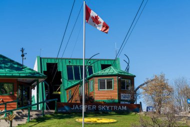 Jasper, Alberta, Kanada - 21 Mayıs 2021: Jasper SkyTram Station with Canadian Flag on a Clear Blue Sky. Kanada 'nın en yüksek ve en uzun güdümlü tramvayı..