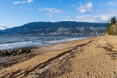 Üçüncü plaj, Stanley Park Seawall. Arka planda West Vancouver şehir manzarası var. British Columbia, Kanada.