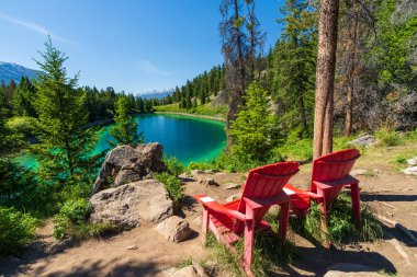 Kırmızı Adirondack sandalyeli Tranquil Turkuaz Gölü, Beş Göller Vadisi, Jasper Ulusal Parkı, Alberta, Kanada.