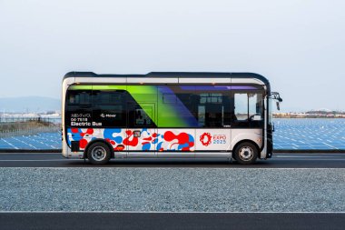 Osaka, Japonya - 16 Nisan 2025: Osaka-Kansai Fuarı 'nda dahili ulaşım için çalışan bir elektrikli araç (EV) servis otobüsü.