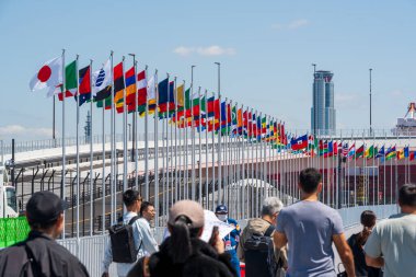 Osaka, Japonya - 24 Nisan 2025: Dünya Fuarı 2025 Osaka, Kansai, Japonya 'ya dalgalı bayraklar altında giren kalabalık.
