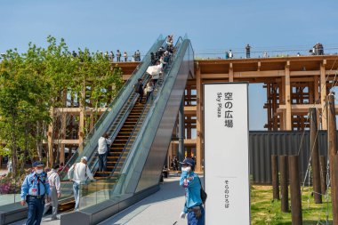 Osaka, Japonya - 30 Nisan 2025: Ziyaretçiler Sky Plaza 'dan Expo 2025' teki Grand Ring 'e yürüyen merdivenle çıkıyorlar.