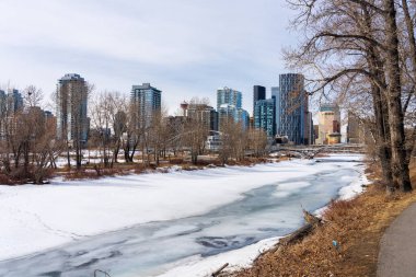 Calgary, AB, Kanada - 14 Mart 2022: Kışın Bow River Yolu. Donmuş Bow Nehri, St. Patricks Adası Parkı. Calgary şehir merkezi..