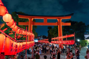 Kyoto, Japonya - 20 Temmuz 2024: Yoimiya Festivali gecesi Fushimi Inari Taisha 'nın fener kaplı ikinci Torii kapısı ve Omotesando yolu.