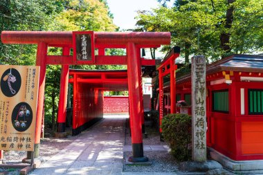 Inuyama, Aichi, Japonya - 22 Temmuz 2024: Inuyama Kalesi 'ne giden ünlü bir yol olan Sanko Inari Tapınağı' nın canlı kırmızı torii kapıları tüneli.