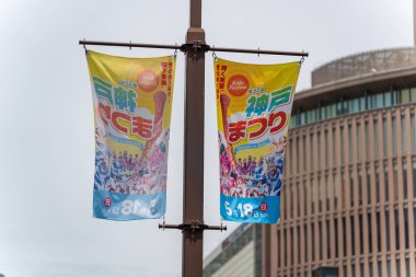 Kobe, Hyogo, Japonya - 18 Mayıs 2025: Sokak lambalarında asılı 52. Kobe Festivali için tanıtım bayrakları.