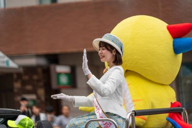 Kobe, Hyogo, Japonya - 18 Mayıs 2025: Hyogo Valiliği maskotu 'Habatan' ve Çiçek Prensesi Hyogo Omatsuri Geçit Töreni 'nde bir arabadan tatlı bir gülümsemeyle el sallıyorlar..