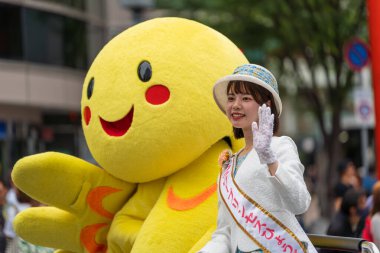 Kobe, Hyogo, Japonya - 18 Mayıs 2025: Hyogo Valiliği maskotu 'Habatan' ve Çiçek Prensesi Hyogo Omatsuri Geçit Töreni 'nde bir arabadan tatlı bir gülümsemeyle el sallıyorlar..