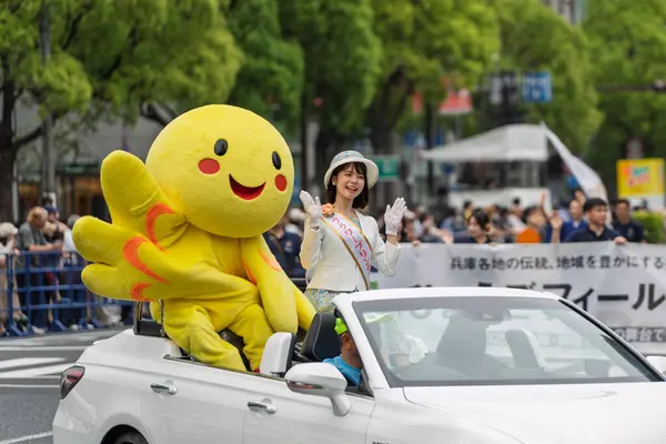 Kobe, Hyogo, Japonya - 18 Mayıs 2025: Hyogo Valiliği maskotu 'Habatan' ve Çiçek Prensesi Hyogo Omatsuri Geçit Töreni 'nde bir arabadan tatlı bir gülümsemeyle el sallıyorlar..