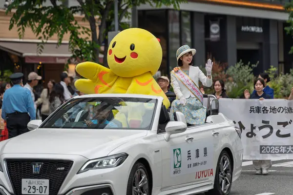 Kobe, Hyogo, Japonya - 18 Mayıs 2025: Hyogo Valiliği maskotu 'Habatan' ve Çiçek Prensesi Hyogo Omatsuri Geçit Töreni 'nde bir arabadan tatlı bir gülümsemeyle el sallıyorlar..