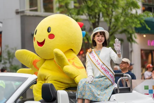 Kobe, Hyogo, Japonya - 18 Mayıs 2025: Hyogo Valiliği maskotu 'Habatan' ve Çiçek Prensesi Hyogo Omatsuri Geçit Töreni 'nde bir arabadan tatlı bir gülümsemeyle el sallıyorlar..