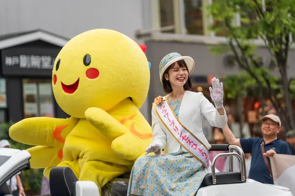 Kobe, Hyogo, Japonya - 18 Mayıs 2025: Hyogo Valiliği maskotu 'Habatan' ve Çiçek Prensesi Hyogo Omatsuri Geçit Töreni 'nde bir arabadan tatlı bir gülümsemeyle el sallıyorlar..