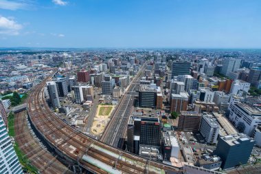 Sendai, Japonya - 4 Ağustos 2024: JR Sendai İstasyonu ve AER Gözlem Terası 'ndan demiryolu hatları ile Sendai şehir manzarasının panoramik görünümü.