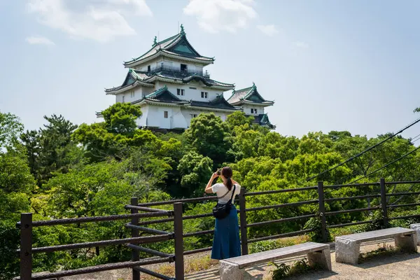 Turistler, Japonya 'daki açık bir yaz gününde Honmaru Sarayı' ndan alınan ikonik Wakayama Kalesi 'nin kalıntılarının fotoğraflarını çekiyorlar..