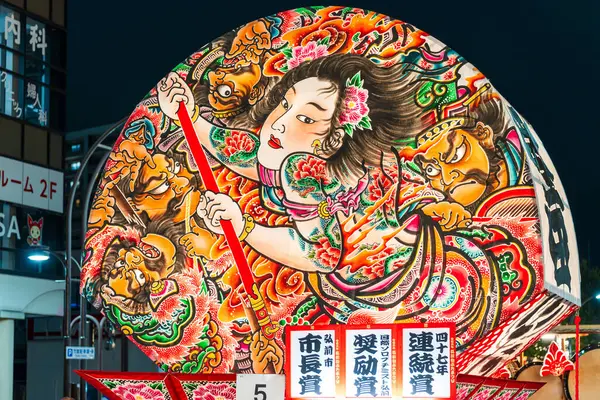 Hirosaki, Aomori, Japonya - 5 Ağustos 2024: Hirosaki Neputa Festivali. Uçsuz bucaksız ve aydınlık hayran şekilli Neputa şamandırası bir müzik grubuyla birlikte sokaklarda süzülüyor..