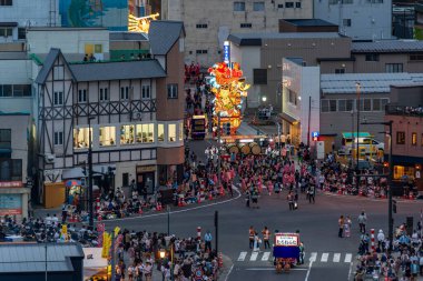Goshogawara, Aomori, Japan - August 7 2024 : Aerial view of the Goshogawara Tachineputa Festival parade, with glowing floats and massive crowds on the city streets.