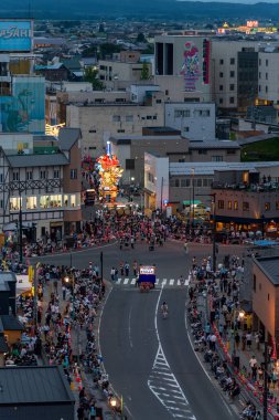 Goshogawara, Aomori, Japan - August 7 2024 : Aerial view of the Goshogawara Tachineputa Festival parade, with glowing floats and massive crowds on the city streets.