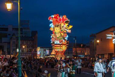 Goshogawara, Aomori, Japan - August 7 2024 : A massive Tachineputa float parades through crowded streets during the Goshogawara Tachineputa Festival night parade.