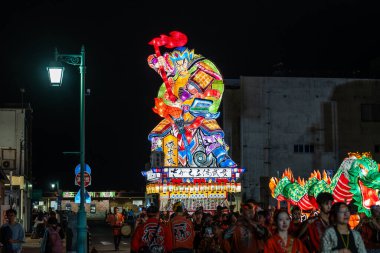 Goshogawara, Aomori, Japonya - 7 Ağustos 2024: Goshogawara Tachineputa Festivali gecesi geçit töreni sırasında kalabalık caddelerde büyük bir takineputa geçit töreni.