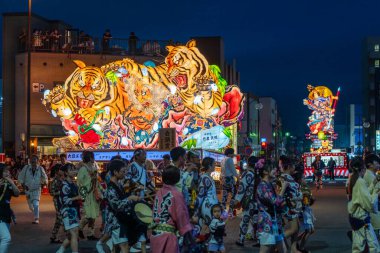 Goshogawara, Aomori, Japan - August 7 2024 : Participants pull a massive nebuta float during the Goshogawara Tachineputa Festival, an energetic night time street parade.