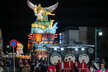 Goshogawara, Aomori, Japonya - 7 Ağustos 2024: Geleneksel kıyafet giymiş Hayashi müzisyenleri, Goshogawara Takineputa Festivali gece geçit töreni için güçlü bir ritim yaratarak Taiko davul çalıyorlar.