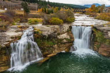 Sonbaharda Crowsnest Nehri 'ndeki Lundbreck Şelalesi' nin arkasında demiryolu köprüsü var. Alberta, Kanada.