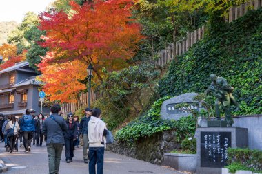 Minoh, Osaka, Japonya - 7 Aralık 2024: Minoh Park 'taki Takimichi patikası boyunca güzel sonbahar renklerinin tadını çıkaran turistler.