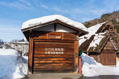 Gifu, Japonya - 19 Ocak 2025 Shirakawa Village İtfaiye İstasyonu 'nun ahşap garaj kapıları, halkın tarihi köy için hazırlık ve korumasını gösteriyor..