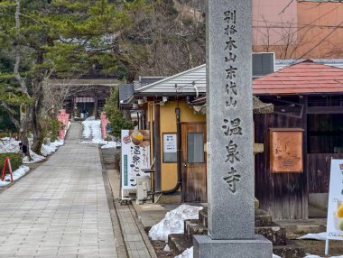 Toyooka, Hyogo, Japonya - 28 Şubat 2025: Kinosaki Onsen 'deki tarihi bir tapınak olan Onsenji' ye sakin yaklaşım yolunun gündüz görünümü.