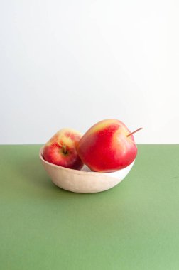 Beyaz ve yeşil arkaplan üzerinde parlak kırmızı elmalar ve metin için telif alanı.