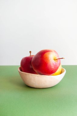 Beyaz ve yeşil arkaplan üzerinde parlak kırmızı elmalar ve metin için telif alanı.