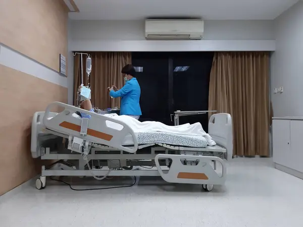Elderly patient lying on bed in hospital while nurse prepare medicine to medical ,health concept