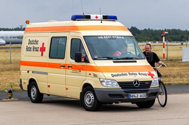 Deutsches Rotes Kreuz  (German Red Cross) Mercedes-Benz Sprinter on stand-by during the Open House of NATO Geilenkirchen Air Base. Germany - July 2, 2017  clipart