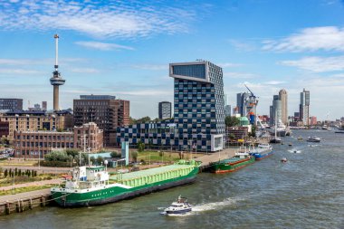 Ships and the STC Building on Lloydstraat street in Delfshaven district of Rotterdam. In the background is the Euromast the buildings at Kop van Zuid. Rotterdam, The Netherlands - Sep 9, 2018 clipart