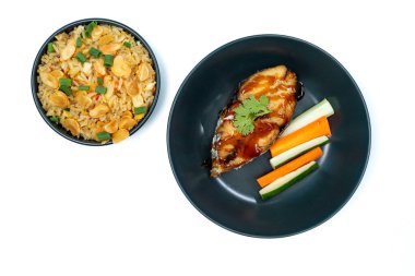 Beyaz arka planda sarımsaklı pilav, teriyaki soslu uskumru, havuç ve salatalık. Üst görünüm.